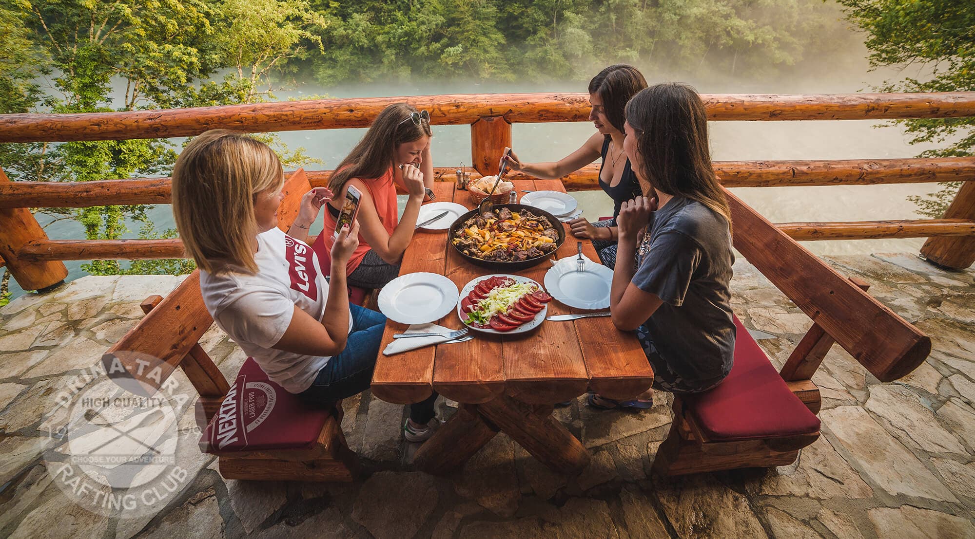 Cetiri mlade djevojke rucaju na terasi rafting centra drina tara, iznad rijeke